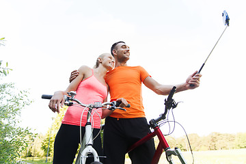 Image showing couple with bicycle and smartphone selfie stick