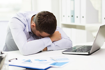 Image showing businessman with laptop and papers in office