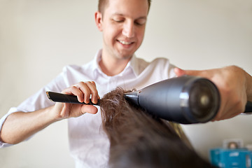 Image showing  close up of stylist making hairdo at salon