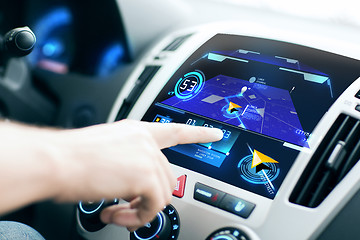 Image showing male hand using navigation system on car dashboard