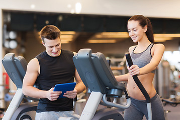 Image showing woman with trainer exercising on stepper in gym