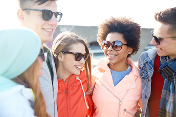 Image showing happy teenage friends in shades talking on street