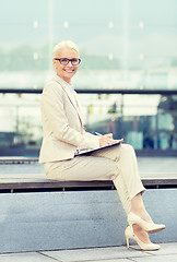 Image showing young smiling businesswoman with notepad outdoors