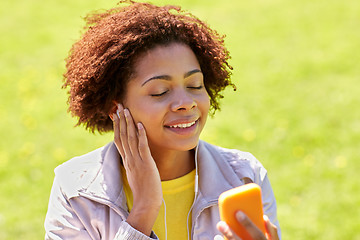 Image showing happy african woman with smartphone and earphones