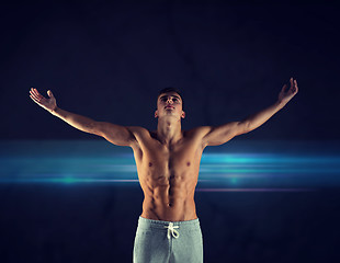 Image showing young male bodybuilder with raised hands