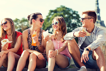 Image showing group of smiling friends sitting on city square