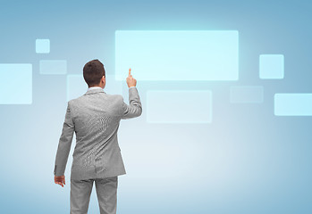 Image showing businessman pointing finger to virtual screen