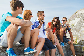 Image showing happy teenage friends talking outdoors