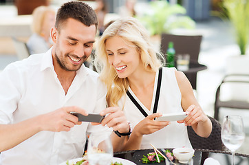 Image showing happy couple with smatphone photographing food