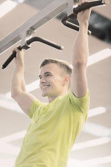 Image showing smiling man exercising in gym