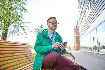 Image showing happy young hipster man with smartphone and bike