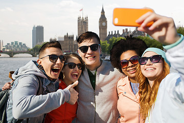 Image showing smiling friends taking selfie with smartphone