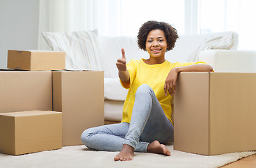 Image showing happy african woman with cardboard boxes at home