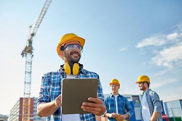 Image showing builder in hardhat with tablet pc at construction