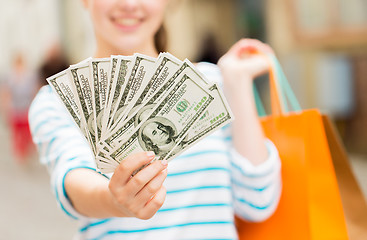 Image showing close up of woman with shopping bags and money