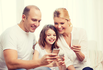 Image showing parents and little girl with smartphones at home