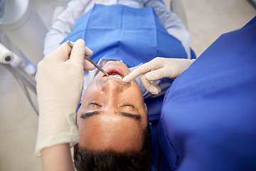 Image showing close up of dentist checking male patient teeth