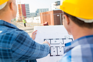 Image showing close up of builders with blueprint at building