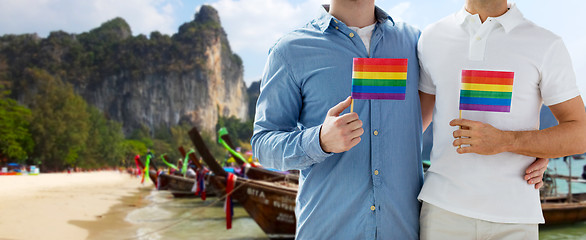 Image showing close up of male gay couple with rainbow flags