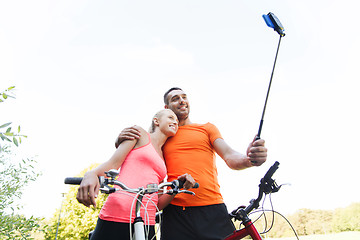 Image showing couple with bicycle and smartphone selfie stick