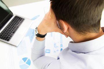 Image showing close up of businessman with laptop and papers