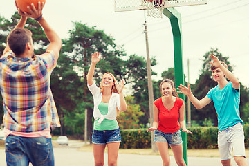 Image showing group of smiling teenagers playing basketball