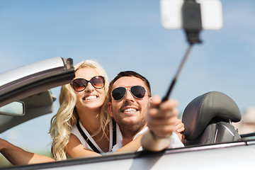 Image showing happy couple in car taking selfie with smartphone