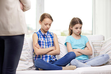 Image showing upset guilty little girls sitting on sofa at home