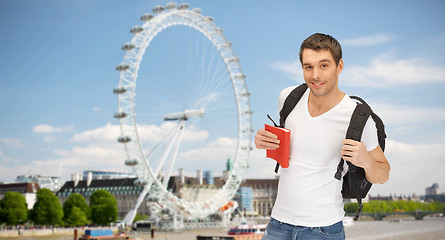 Image showing happy young man with backpack and book travelling