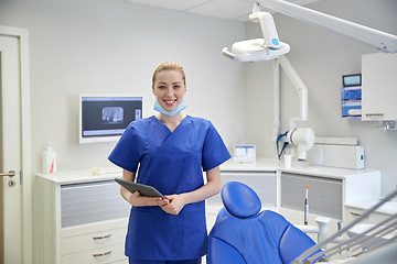 Image showing happy female dentist with tablet pc at clinic