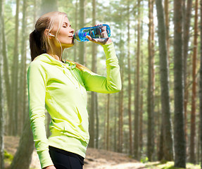 Image showing woman drinking water after doing sports outdoors