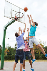 Image showing group of happy teenage friends playing basketball