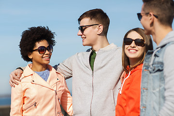 Image showing happy teenage friends in shades talking on street