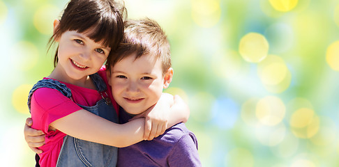 Image showing two happy kids hugging over green lights