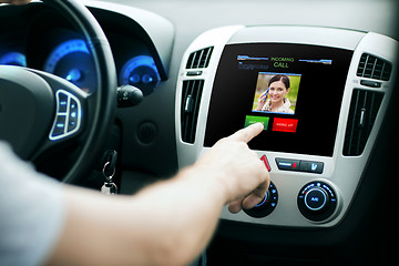 Image showing male hand receiving video call on car panel screen