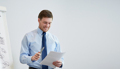 Image showing smiling businessman on presentation in office