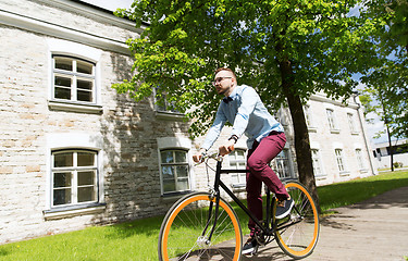 Image showing happy young hipster man riding fixed gear bike