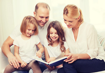 Image showing smiling family and two little girls with book