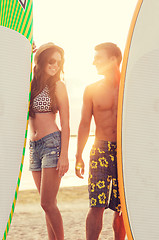 Image showing smiling couple in sunglasses with surfs on beach