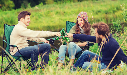 Image showing group of smiling tourists drinking beer in camping