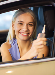 Image showing happy woman getting car key in auto show or salon