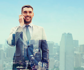 Image showing smiling businessman with smartphone in city