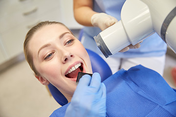 Image showing female patient face with x-ray machine and shield