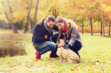 Image showing smiling couple with dog in autumn park