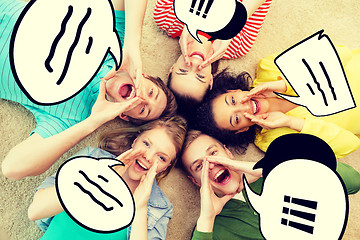 Image showing smiling people lying down on floor and screaming