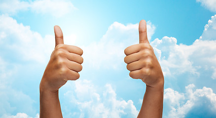 Image showing african hands showing thumbs up over blue sky