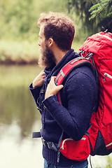 Image showing smiling man with beard and backpack hiking