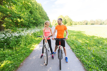 Image showing happy couple riding bicycle outdoors