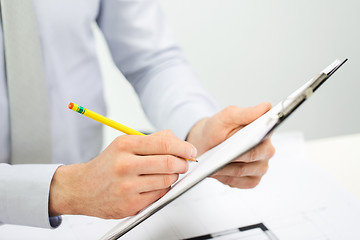 Image showing close up of businessman hands with clipboard