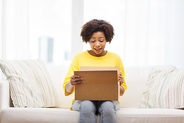 Image showing happy african young woman with parcel box at home